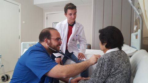 El resident Santi Castejón amb un estudiant de Medicina i una pacient a l'Hospital Universitari de la Santa Creu de Vic.